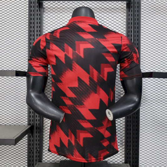 Camisa vermelha e preta do Manchester United para treino pré-jogo 2025/26, versão jogador